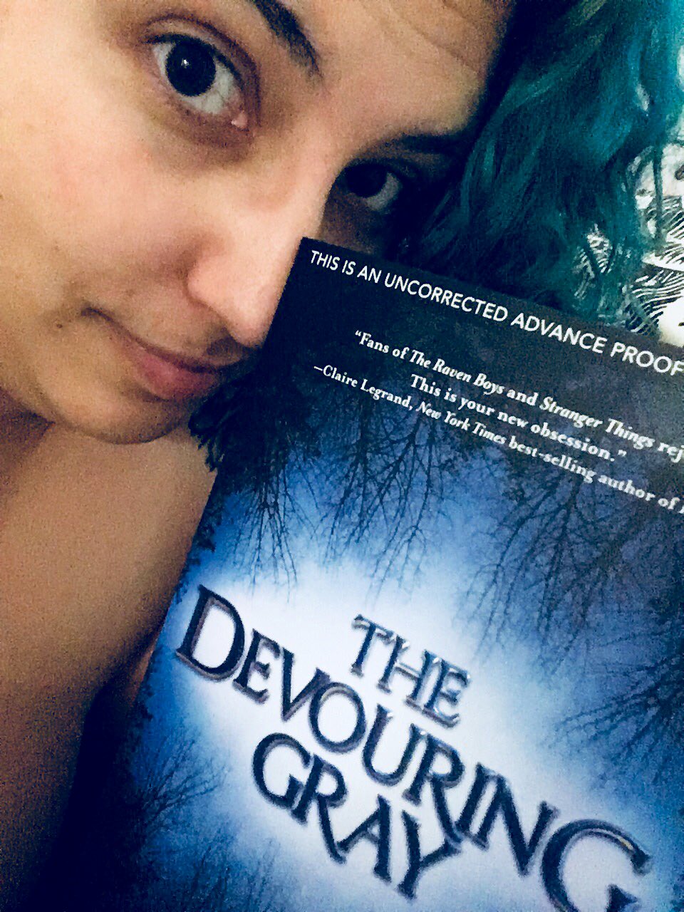 A selfie of me with green hair, holding a physical ARC of The Devouring Gray, by Christine Lynn Herman.